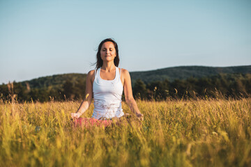 Beautiful woman sitting in lotus position and meditating in the nature,Padmasana/Lotus position.	