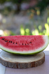 Slice of watermelon, served in a garden. Selective focus.