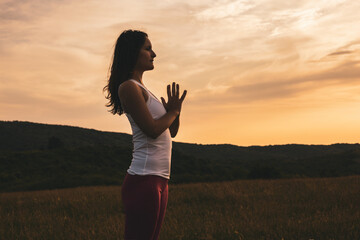 Silhouette of a woman meditating in nature.