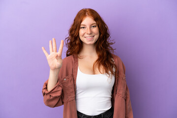 Fototapeta na wymiar Teenager redhead girl over isolated purple background happy and counting four with fingers