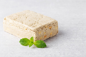 sunflower halva and peanuts on grey background with mint