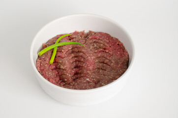 Raw kibbeh, a traditional dish from Arab cuisine, served in a bowl on a white background.