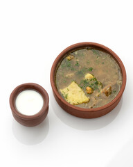 Hearty lunch, meat soup. Pot of meat broth with dill and portion of milk cream. Two pottery with food isolated on white background. Top view.