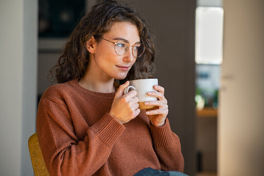 Young woman drinking tea at home during winter