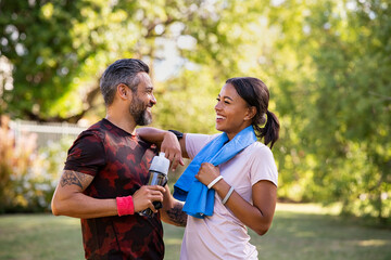 Mixed race couple taking a break after jog at park