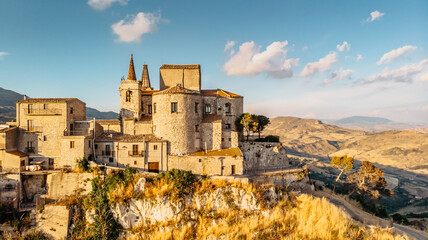 Aerial view of medieval stone village,the highest village in Madonie mountain range,Sicily,Italy.Church of Santa Maria di Loreto at sunset.Picturesque stone houses,narrow cobbled streets,views of town