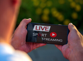 Man watching sport live stream via smartphone in free time. Leisure activities concept.