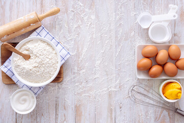 Homemade dough recipe (eggs, flour, milk, sugar) on a wooden table top view.