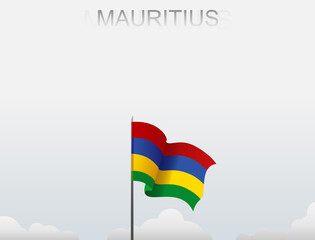 The flag of Mauritius flies on a pole that stands tall against a white sky