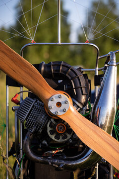 Closeup of a petrol paramotor with a propeller and protection for individual paragliding. Wing flight preparation. Extreme sports. Runway on a green field.