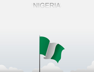 Nigerian flag flutters on a pole standing tall under a white sky