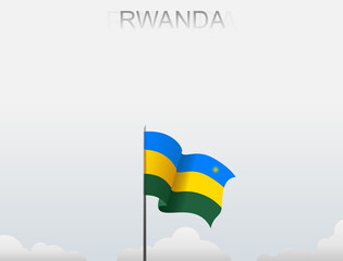 Rwanda flag flutters on a pole standing tall under a white sky