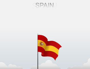 Spain flag flutters on a pole standing tall under a white sky