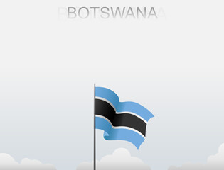 Botswana flag flutters on a pole standing tall under a white sky