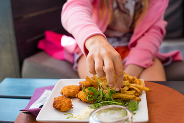 little girl feasting on her plate of fries and nuggets