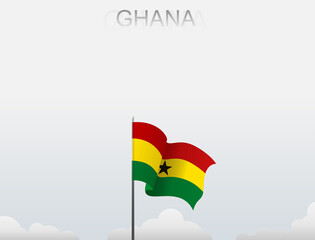 Ghana flag flutters on a pole standing tall under a white sky
