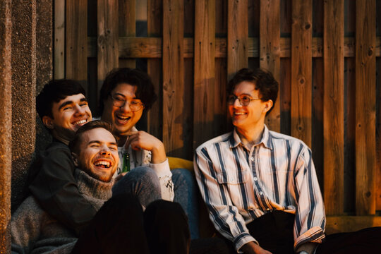 Manliga v&auml;nner umg&aring;s p&aring; balkong och skrattar