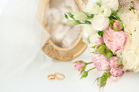 Wedding arrangement. Bridal bouquet, photo framed couple and wedding rings