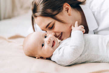 Young mother plays and talks with her newborn baby. Love and care for children. Adoption of...