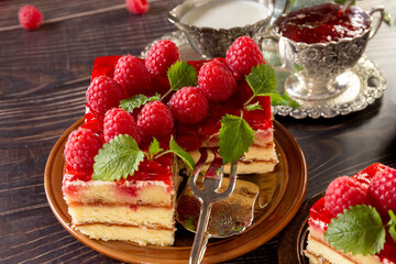 Cake. A piece of beautiful raspberry cake on a plate. Raspberry jam and milk in a silver bowl. Festive food. Bouquet of red roses in a vase. Postcard. Poster.