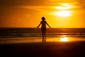 Fototapeta na wymiar happy young girl on the beach at sunset