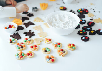 Children prepare cookies with sweets, a boy rolls out the dough with a rolling pin. Leisure activity with children concept