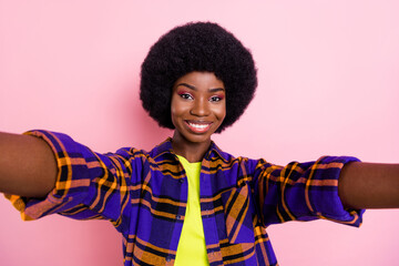 Self-portrait of attractive cheerful girl wearing checked shirt good mood isolated over pink pastel color background