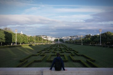 Sitting traveler. amazing view of Lisbon: artistic landscape design hillside green park 