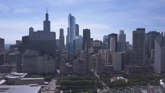 wide drone shot of downtown chicago with millenium park and buildings in foreground