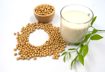 Soybean in wooden bowl and soy milk in glass with leaves, isolated on white background.