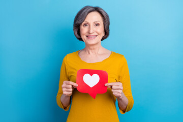 Portrait of attractive cheerful woman holding in hands like comment card web app isolated over bright blue color background