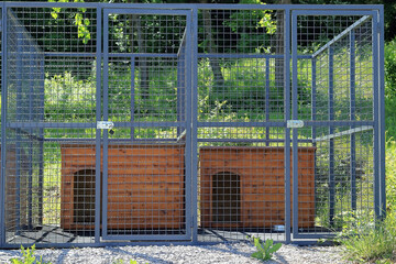 brown wooden dog house in the cage outdoors
