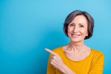 Portrait of attractive cheerful woman showing copy blank ad decision way direction isolated over...