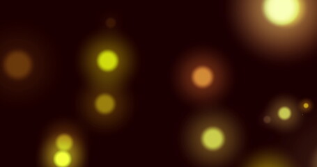 Image of yellow glowing spots of light moving in hypnotic motion on black background