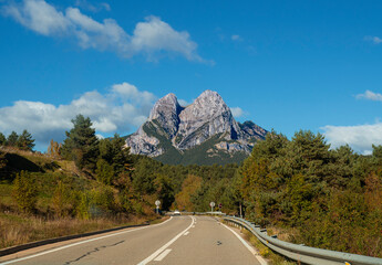 Carretera con la Montaña del Pedraforca en Cataluña, con una forma singular, al fondo con...