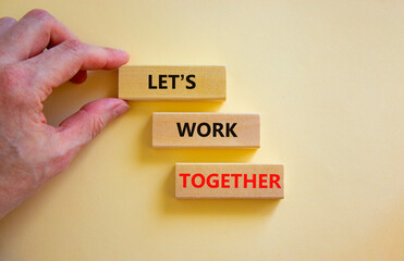Work together symbol. Wooden blocks with words Let is work together on beautiful white background. Businessman hand. Business, let is work together concept. Copy space.