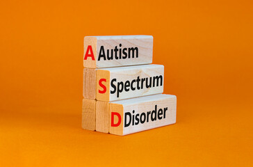 ASD, autism spectrum disorder symbol. Wooden blocks with words 'ASD, autism spectrum disorder'. Orange background. Medical and ASD, autism spectrum disorder concept. Copy space. - obrazy, fototapety, plakaty