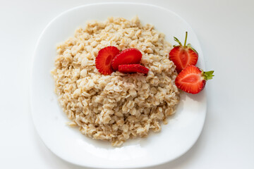 oatmeal with strawberries on a white plate, healthy food