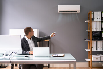 Businessman In Office Using Air Conditioning