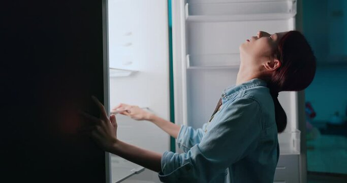 woman look at empty fridge