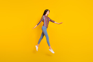 Fototapeta na wymiar Full length profile side photo of young woman happy positive smile jump go walk step isolated over yellow color background