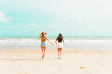 Two Young Asian woman on vacation walking and enjoy the seaside.