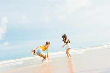 Two Asian women in summer casual clothes play in the sea on the Beach Having Fun.