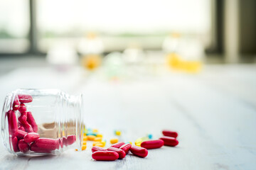 Red pigment pill for treating blood and heart and various vitamins in bottles placed on table in room for patients. Showing the care of the body that is weak, sick due to not taking care of health