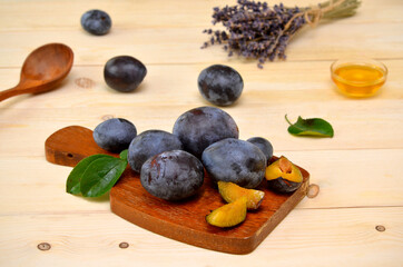 fresh plums on the board and scattered on the table