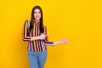 Photo of young woman happy positive smile point fingers empty space advertise select suggest isolated over yellow color background