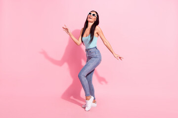 Fototapeta na wymiar Full length body size photo of smiling woman wearing sunglass laughing overjoyed isolated on pastel pink color background