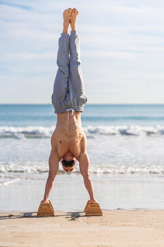 Man in handstand on parallel bars on coast