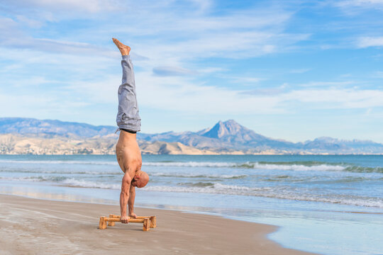 Man in handstand on parallel bars on coast