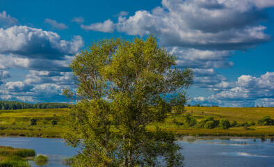 Clouds over the lake and field in autumn